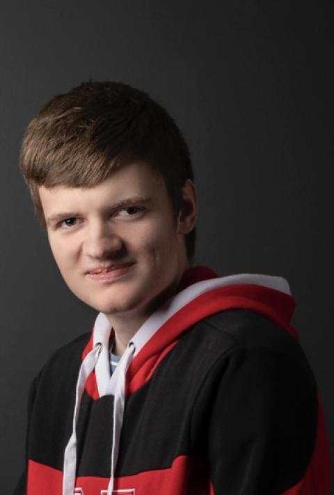 Benjamin wearing a red University of Nebraska hoodie, smiling at the camera.