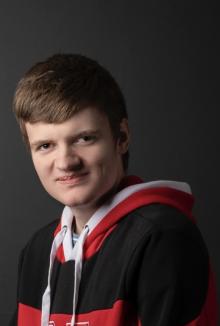 Benjamin wearing a red University of Nebraska hoodie, smiling at the camera.
